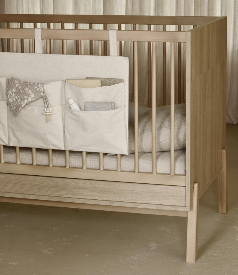 Závěsný kapsář Quax zavěšený na postýlce – přehledné místo pro potřeby miminka